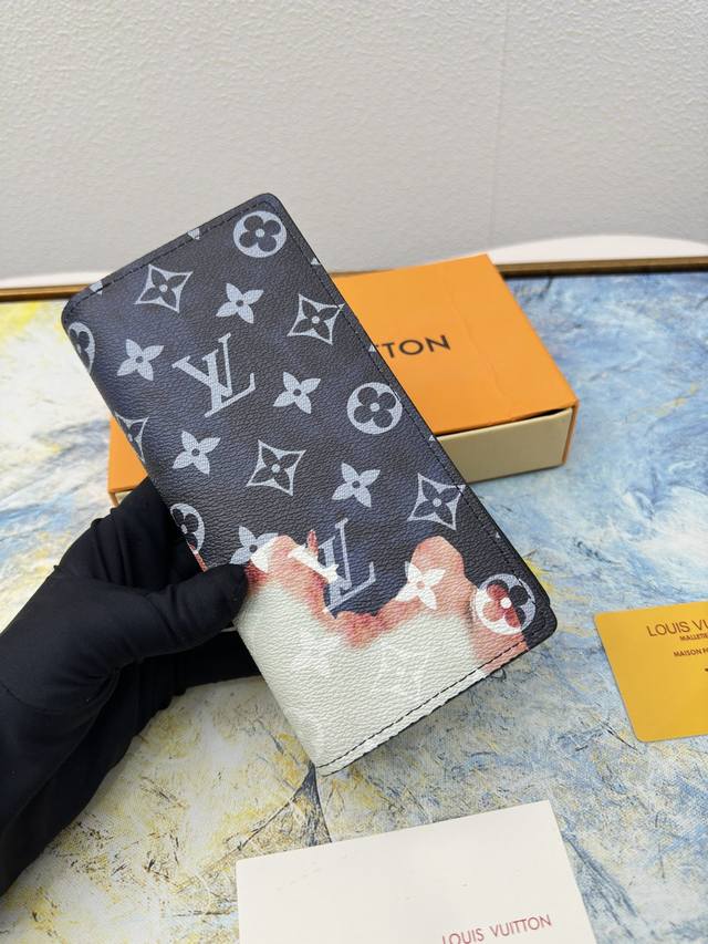 M82826黑花配火焰 Monogram 帆布与标志性 Monogram 图案内里 竖体路易威登标识点缀其上 卡片夹层与钞票隔层提供充裕空间 尺寸 10 19